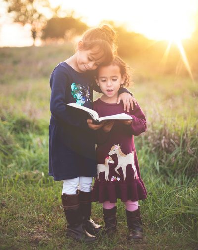 Young sisters reading the bible together
