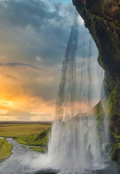 Water fall at sunset with open field background