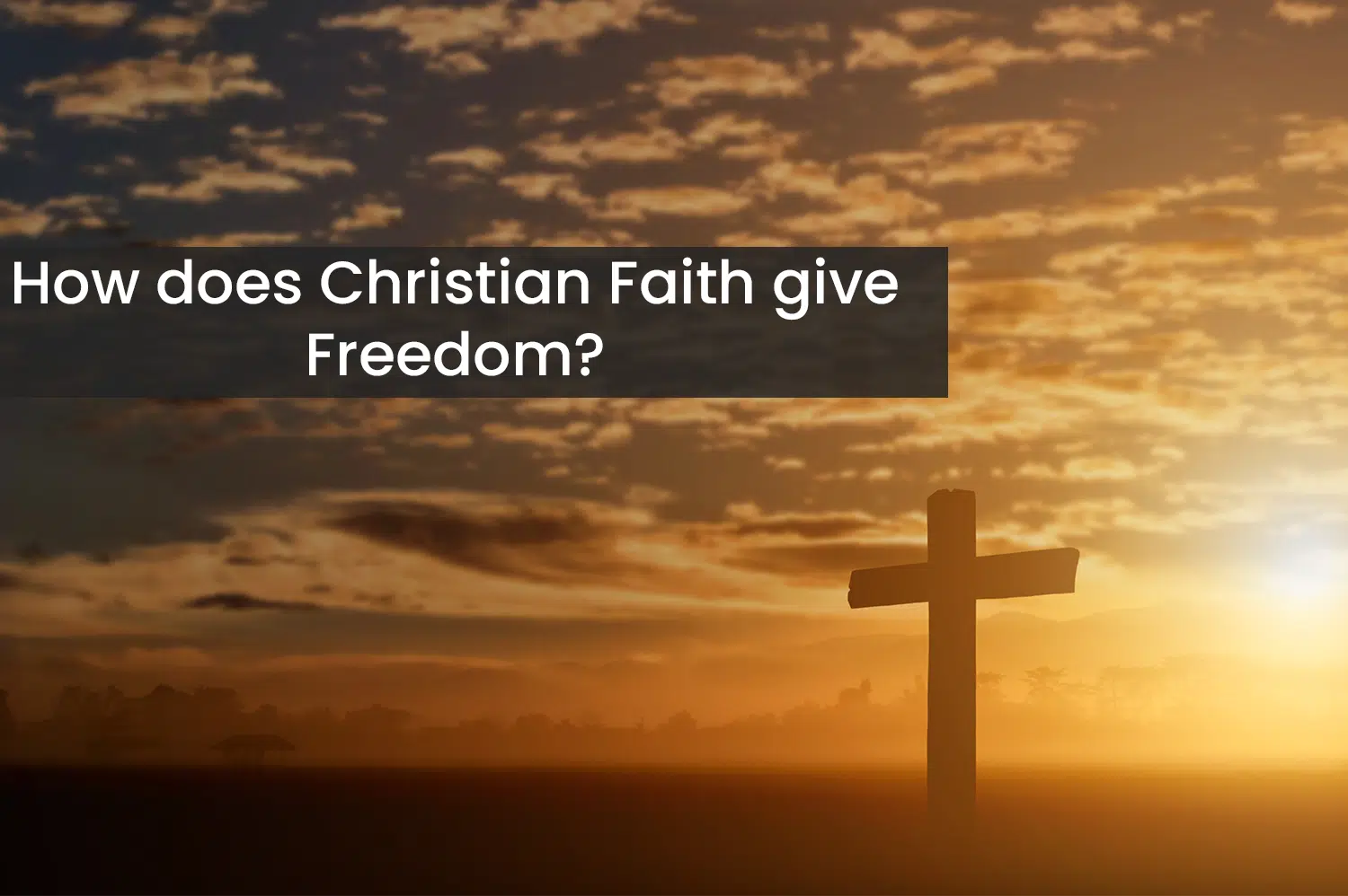 A cross standing in faith in a field in front of a sun set.