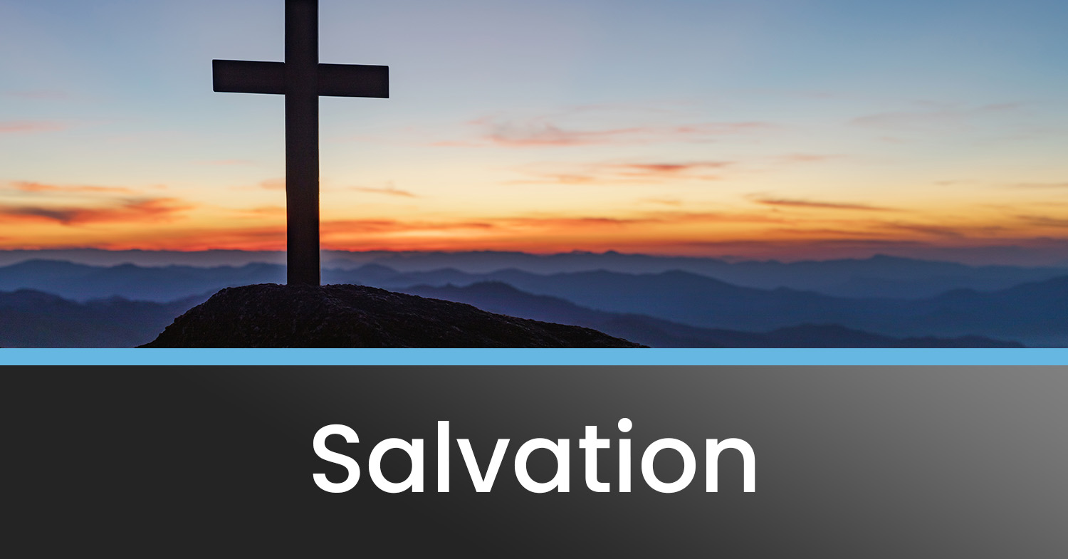 A cross on a hill with a sunset and mountains in the distance - a symbol of salvation.